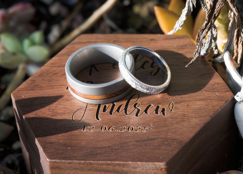 Close-up view of wooden wedding ring boxes with custom engraving and rustic details.