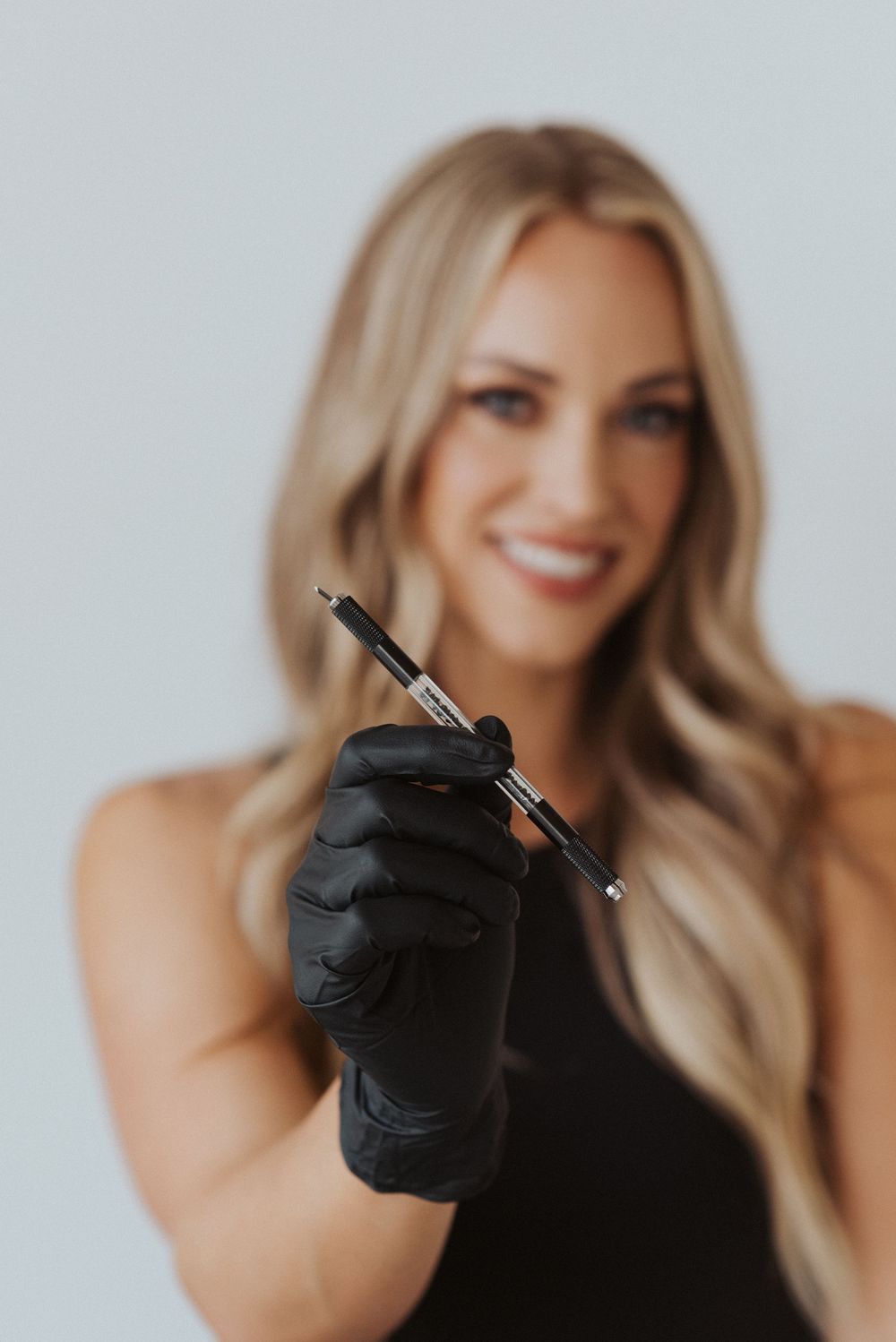 Close-up shot of hands wearing black gloves holding writing instruments.