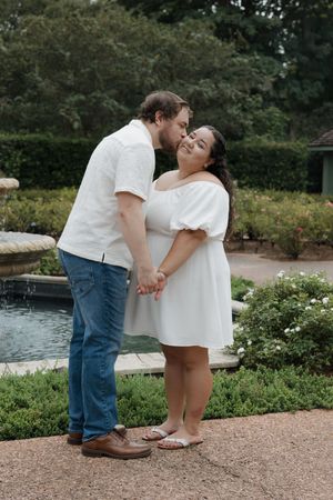 Romantic moment between a couple in a garden with blooming flowers.