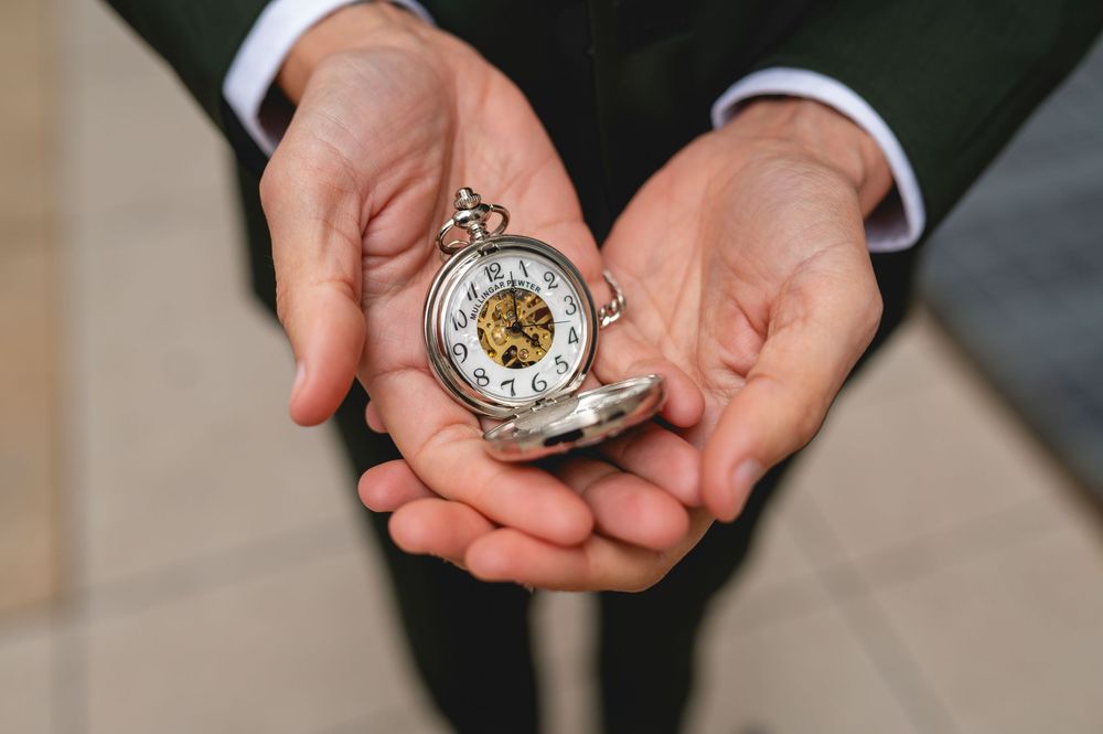 A close-up series of hands holding a vintage pocket watch and demonstrating how to open and inspect its details.