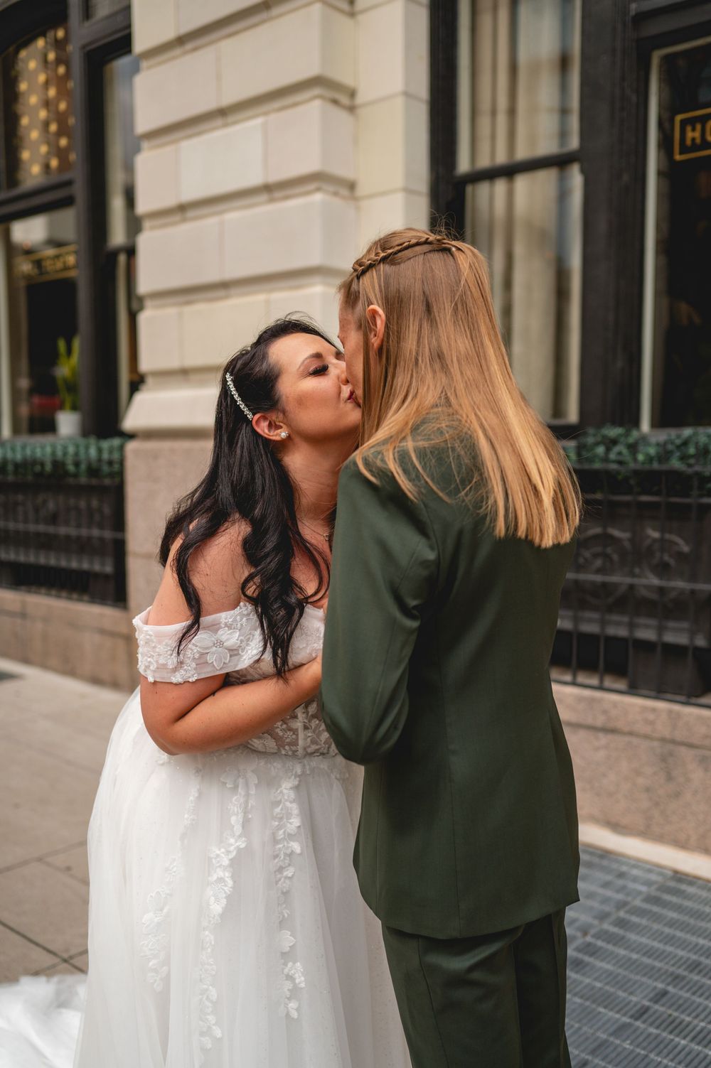 A wedding couple sharing romantic kisses in front of a building in a sequence of connected photos.