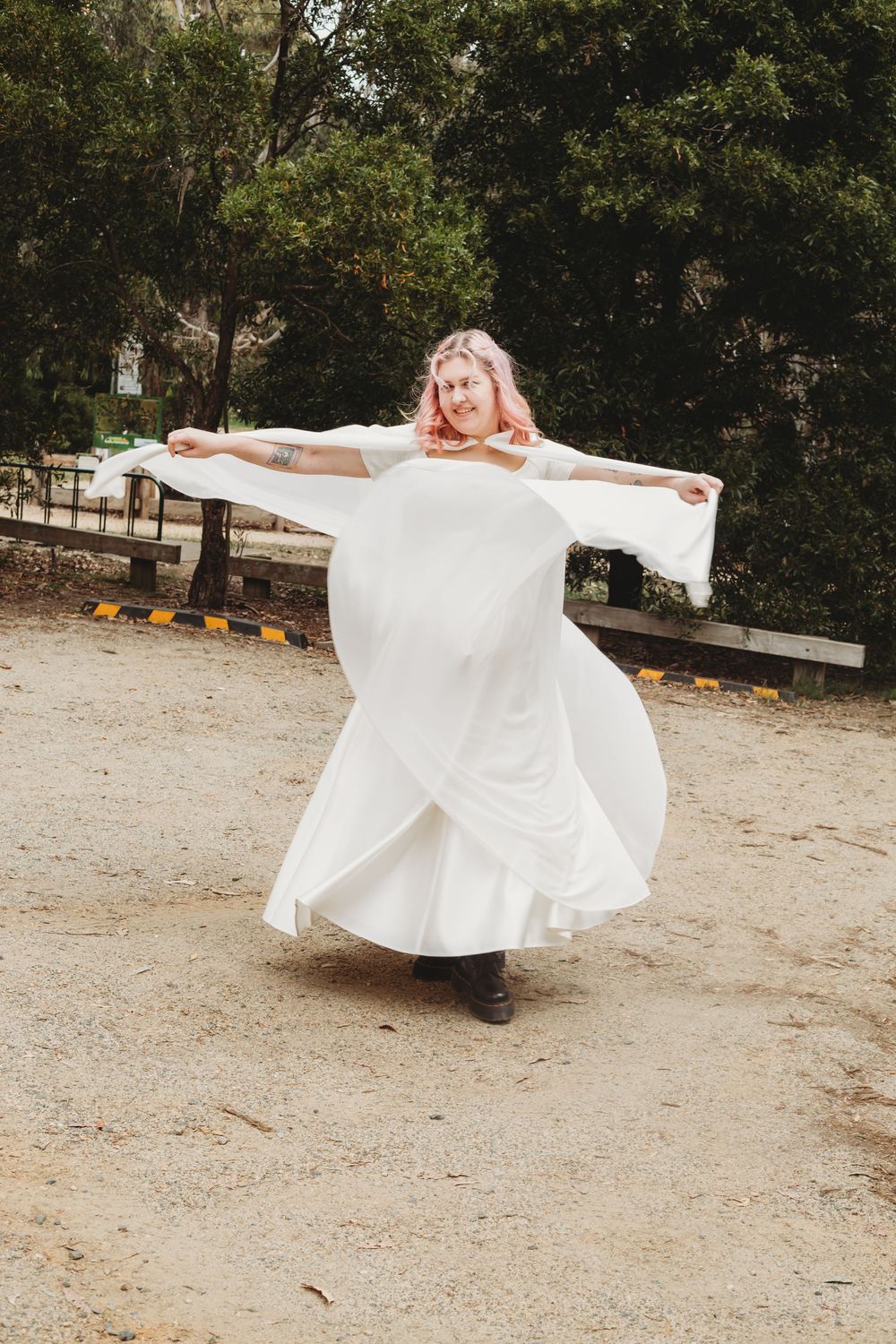 A person in a flowing white dress twirls and spins in a series of progressive movement shots on a dirt path outdoors.
