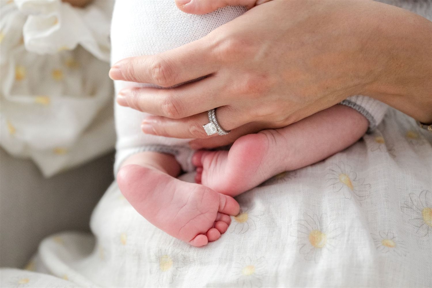 Close-up of hands showing off an elegant engagement ring on white fabric against various backgrounds.