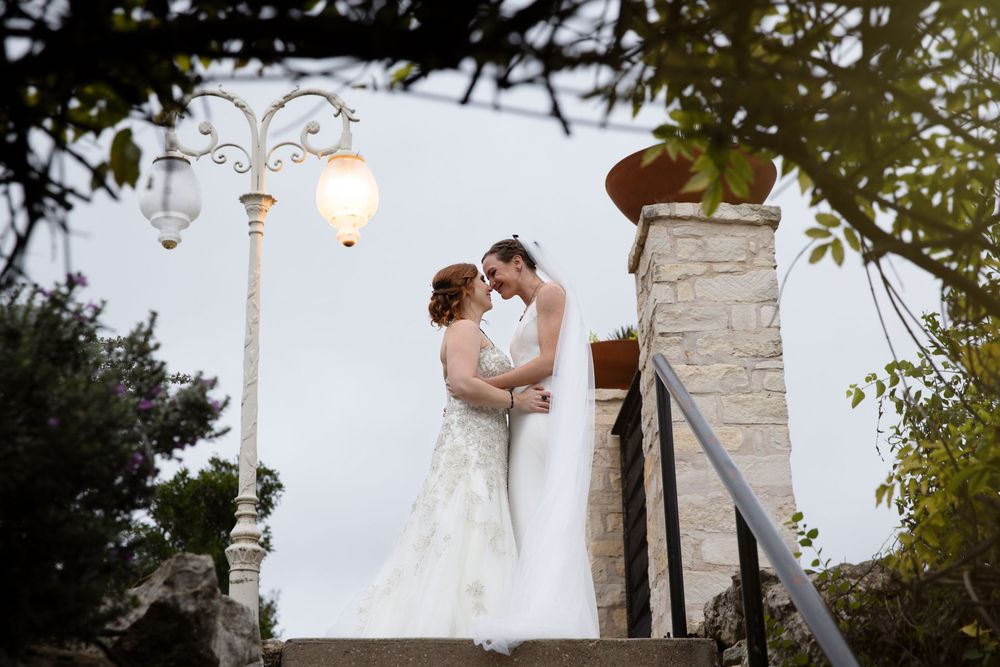 Elegant outdoor wedding ceremony setup with decorative light posts and stone architecture.