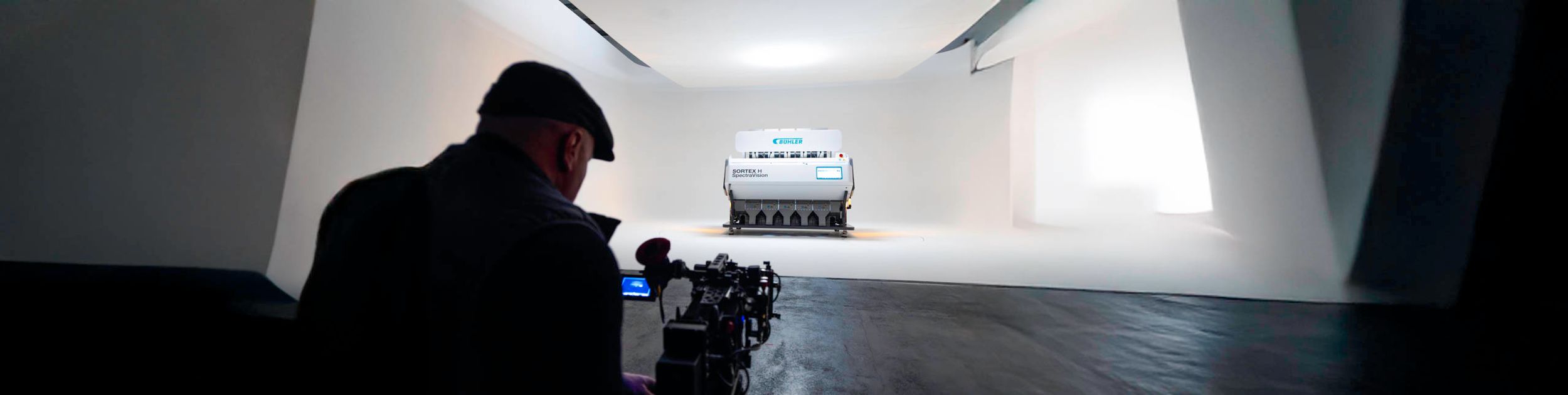 BTS shot of film maker focusing on Buhler sorting machine in studio