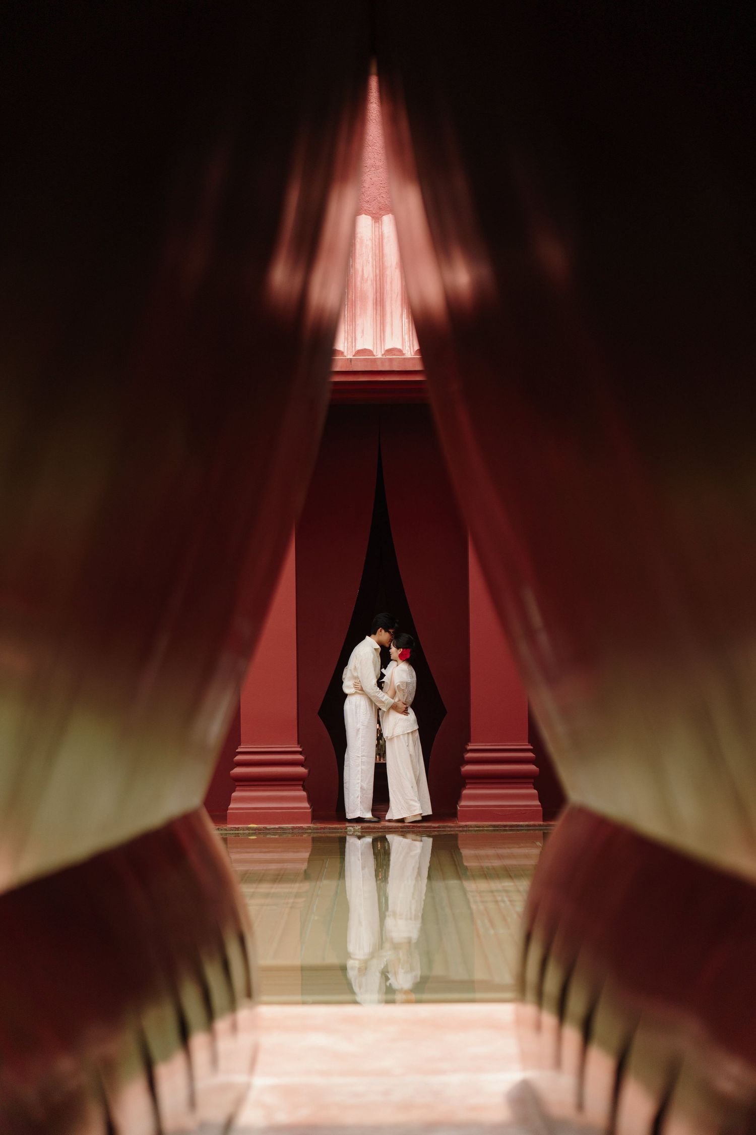 Dramatic silhouette photography in a corridor with red lighting and architectural elements.