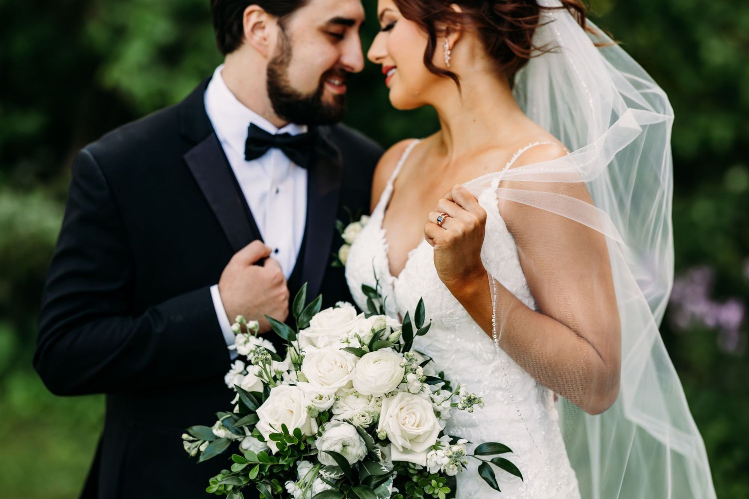 Bride and Groom embracing hands in front of the setting sun with clear waters behind them at Pottawatomie Park in St. Charles, Illinois.