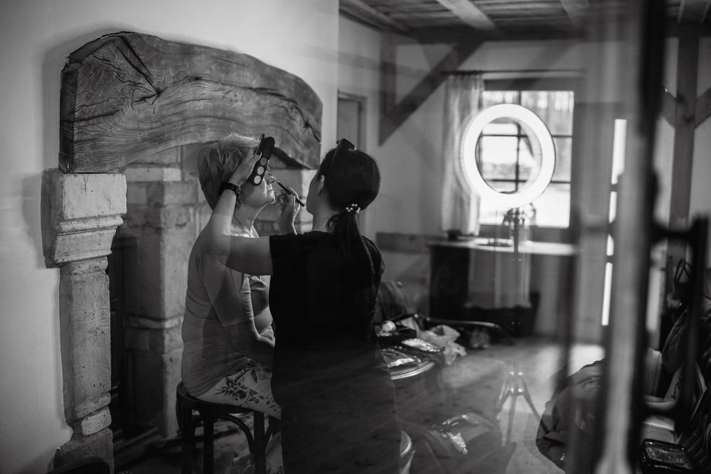 Black and white image of preparation scene through window reflection.