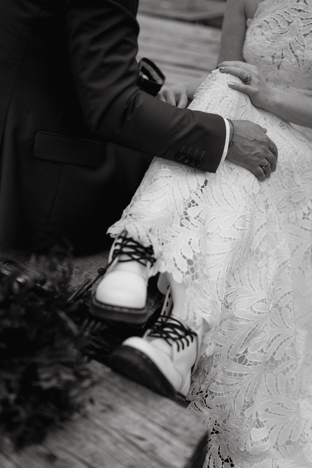 Close-up of couple's feet showing white boots and formal attire.