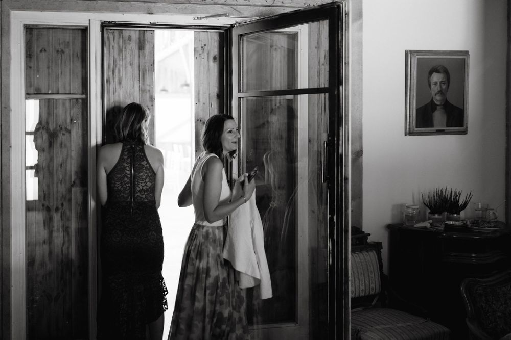 Interior view of rustic wooden doorway with vintage portrait on wall.
