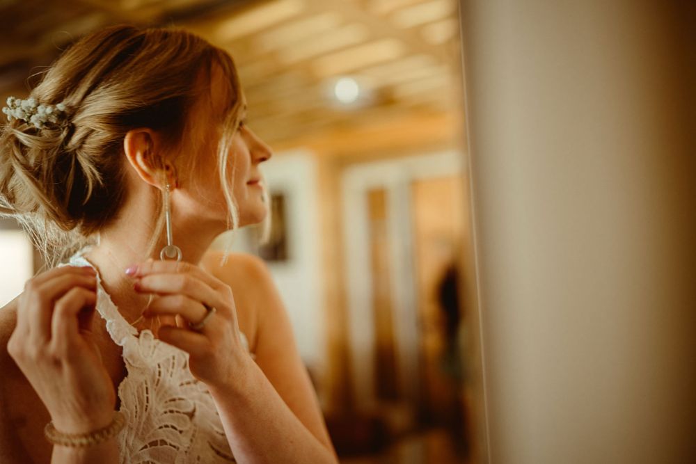 Delicate finishing touches being added to bridal accessories in golden light.