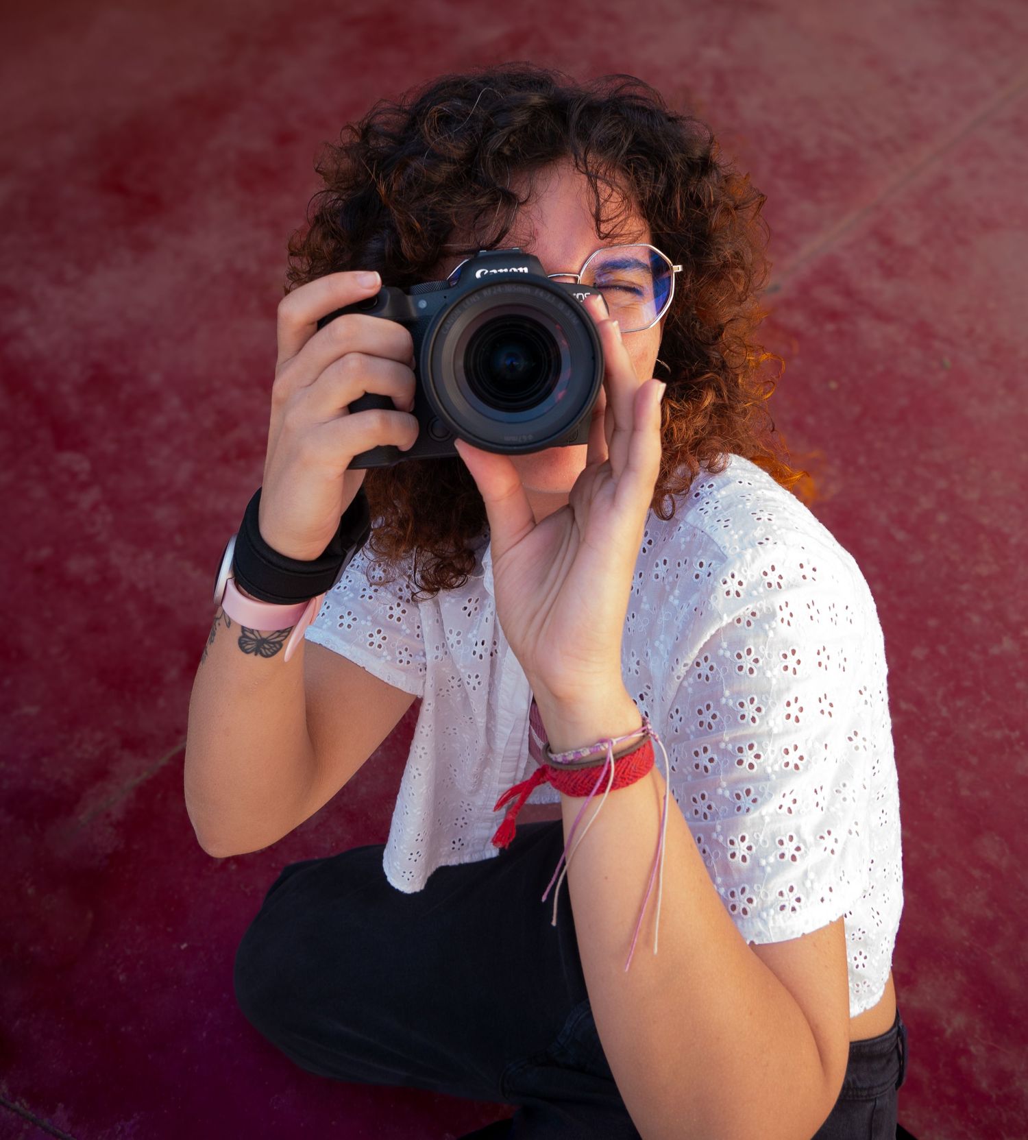 Fotógrafa realizando una fotografía con cámara profesional en una sesión de retrato.