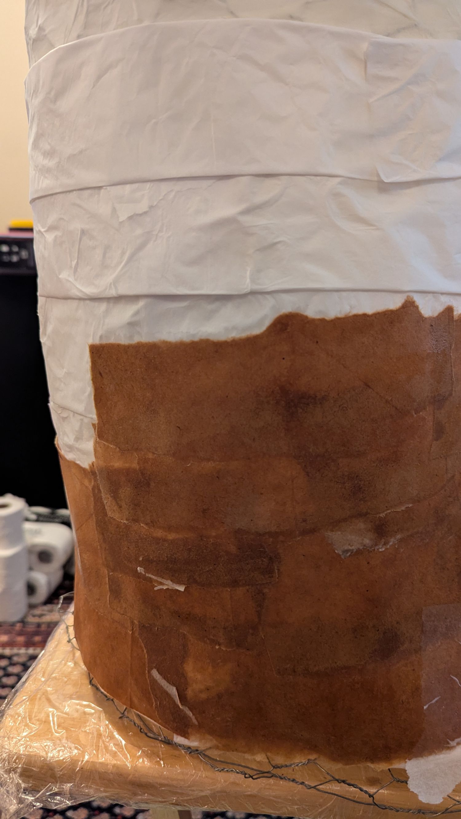 Brown craft paper is being laid over the tissue paper layer.