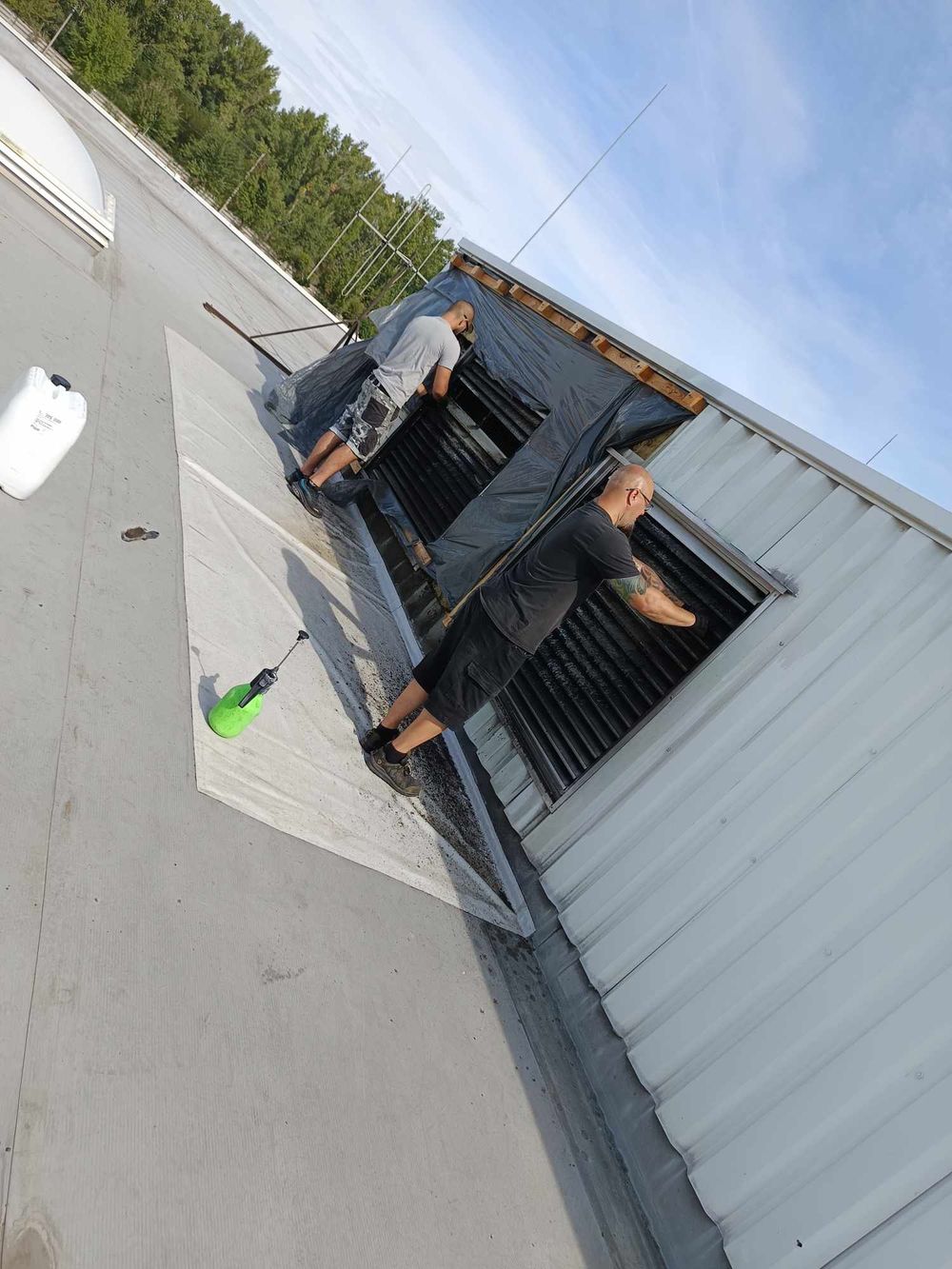 Inspection of a commercial HVAC system on a rooftop showing maintenance access panels.