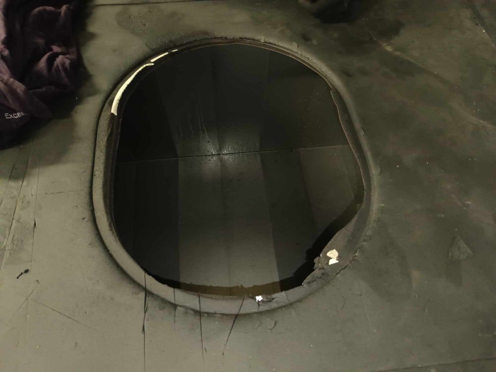 Dark circular opening showing the interior of an industrial ventilation or duct system.