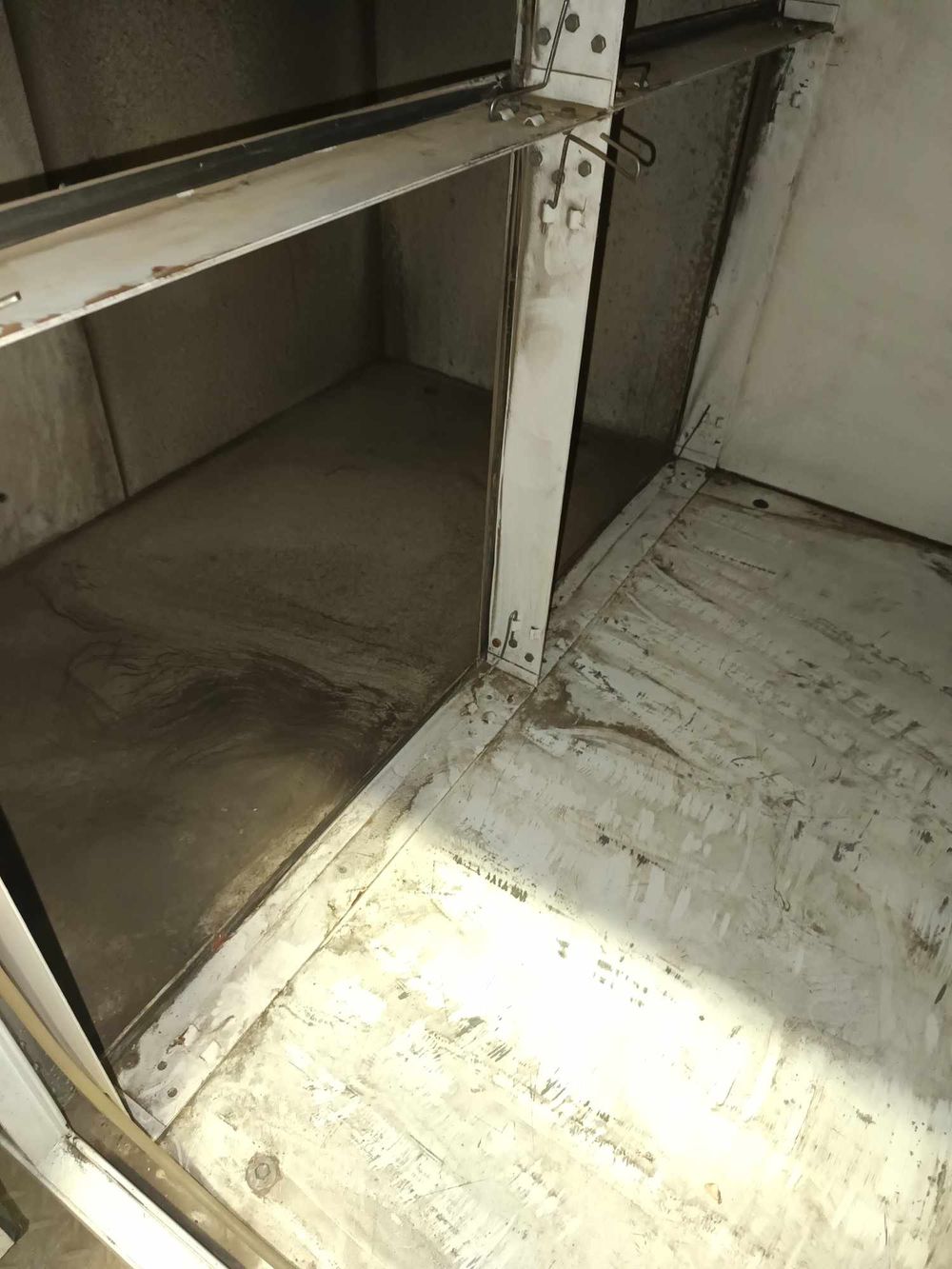 Interior view of an empty industrial storage shelf or platform in a maintenance area.