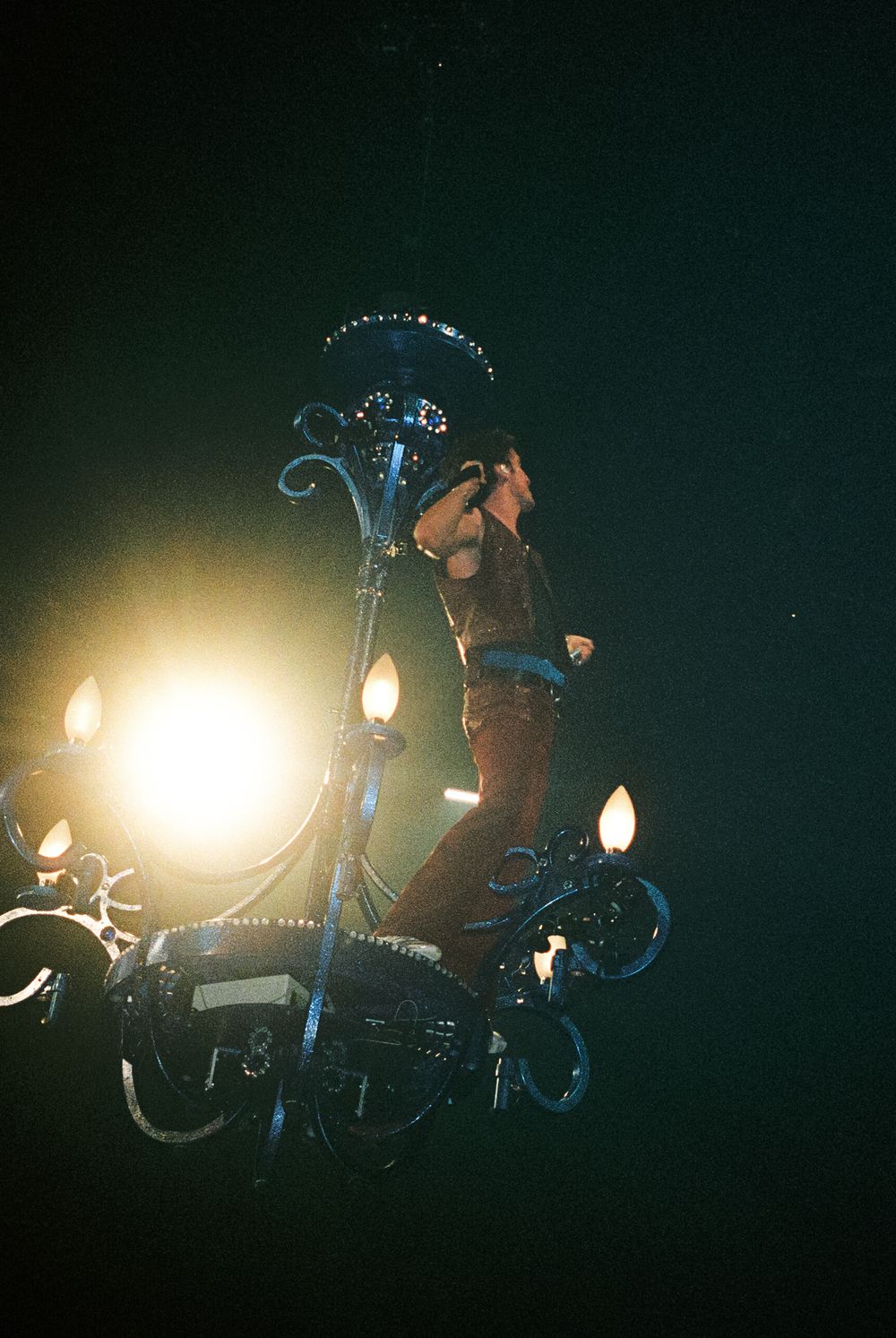 Silhouettes of motorcycles and riders illuminated by bright spotlights against a dark background in a sequential action shot.