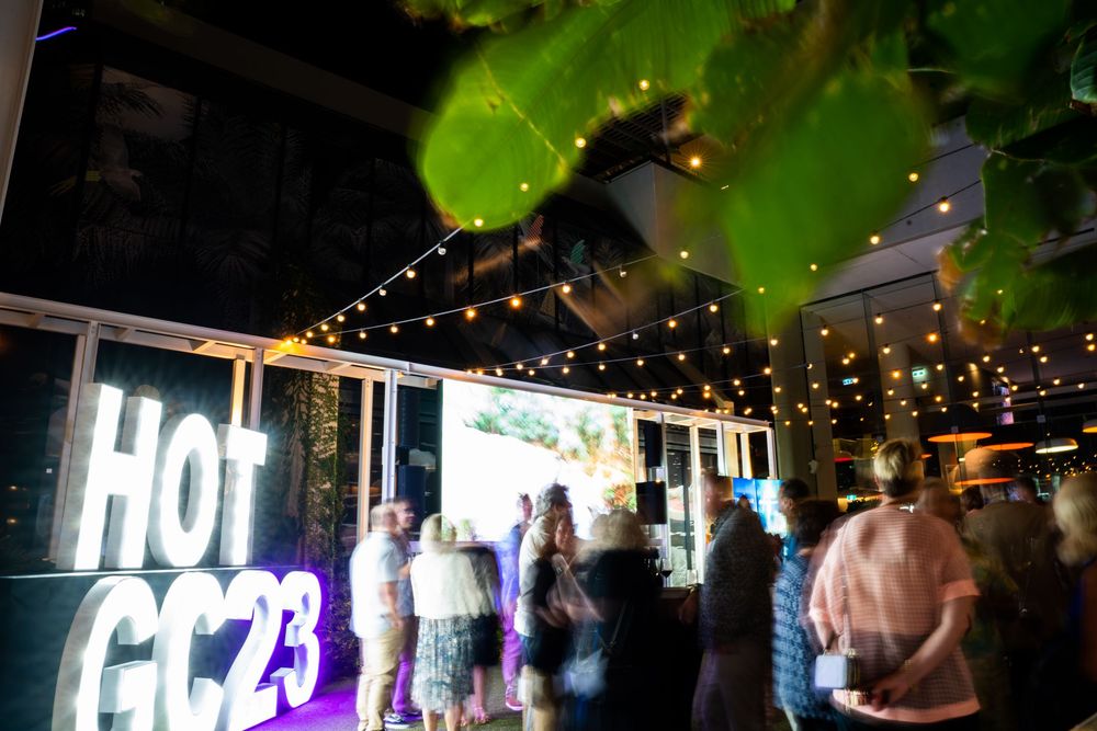 Outdoor event space decorated with string lights and greenery creating an elegant evening atmosphere.