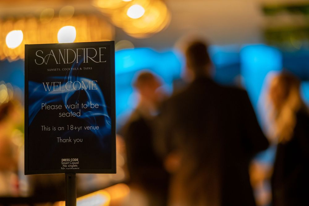 Blurred interior of a restaurant with warm lighting and signage visible in the background.