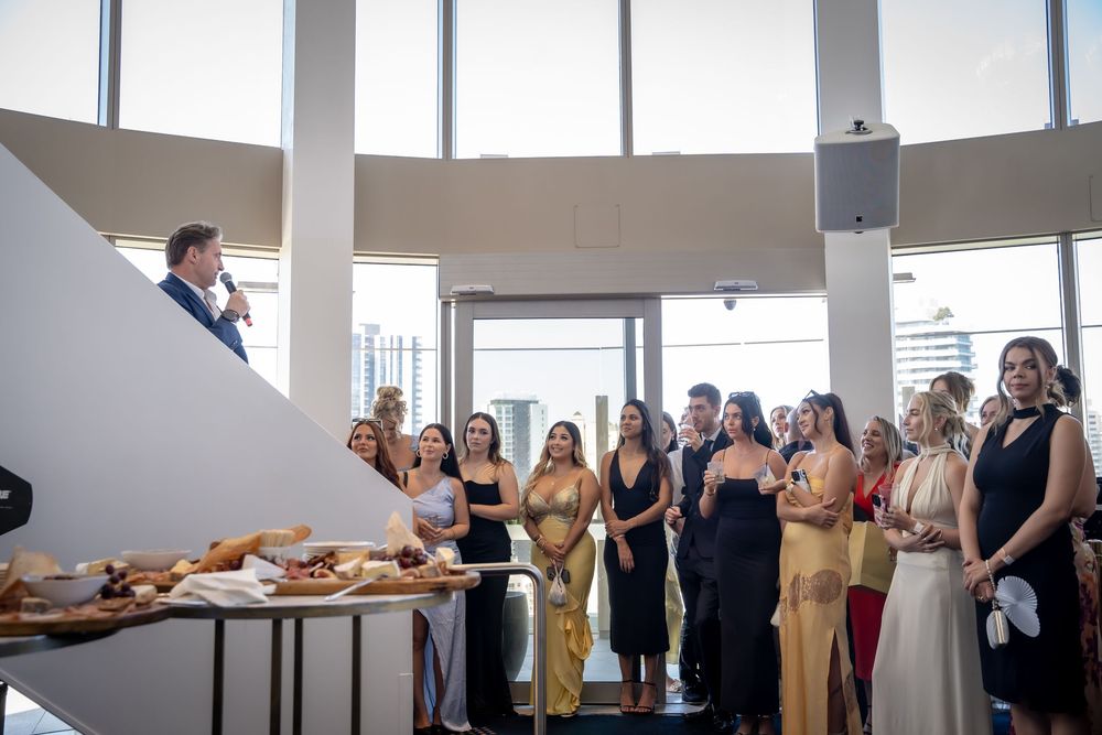 A panoramic sequence of wedding guests mingling and socializing at an elegant reception venue with large windows.