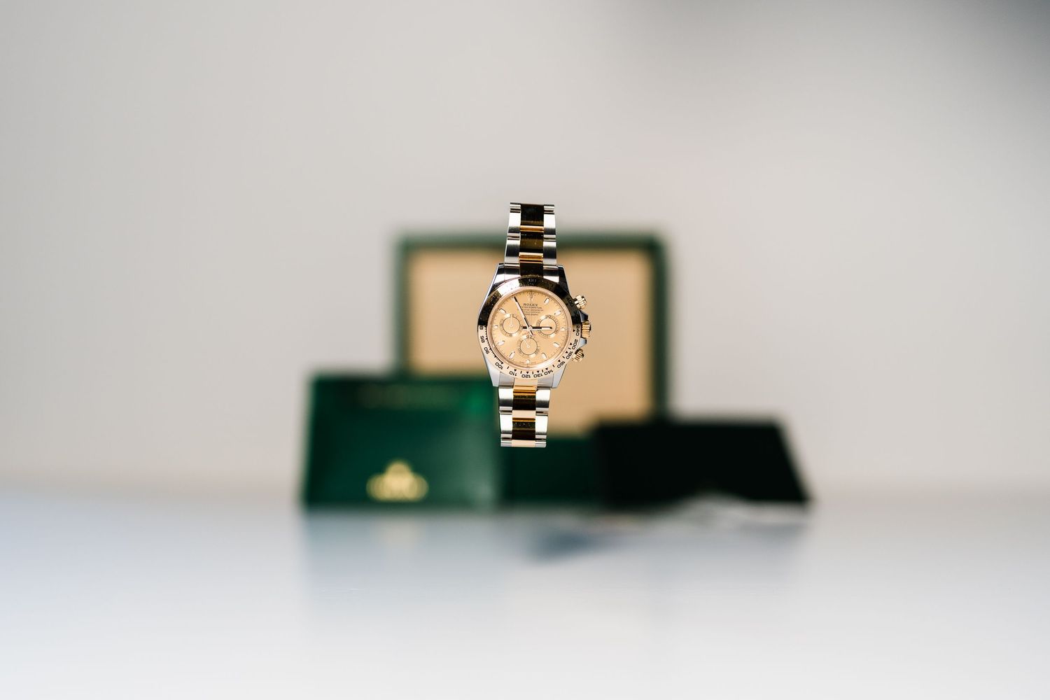 A small green and gold jewelry box sits alone against a blurred white background.