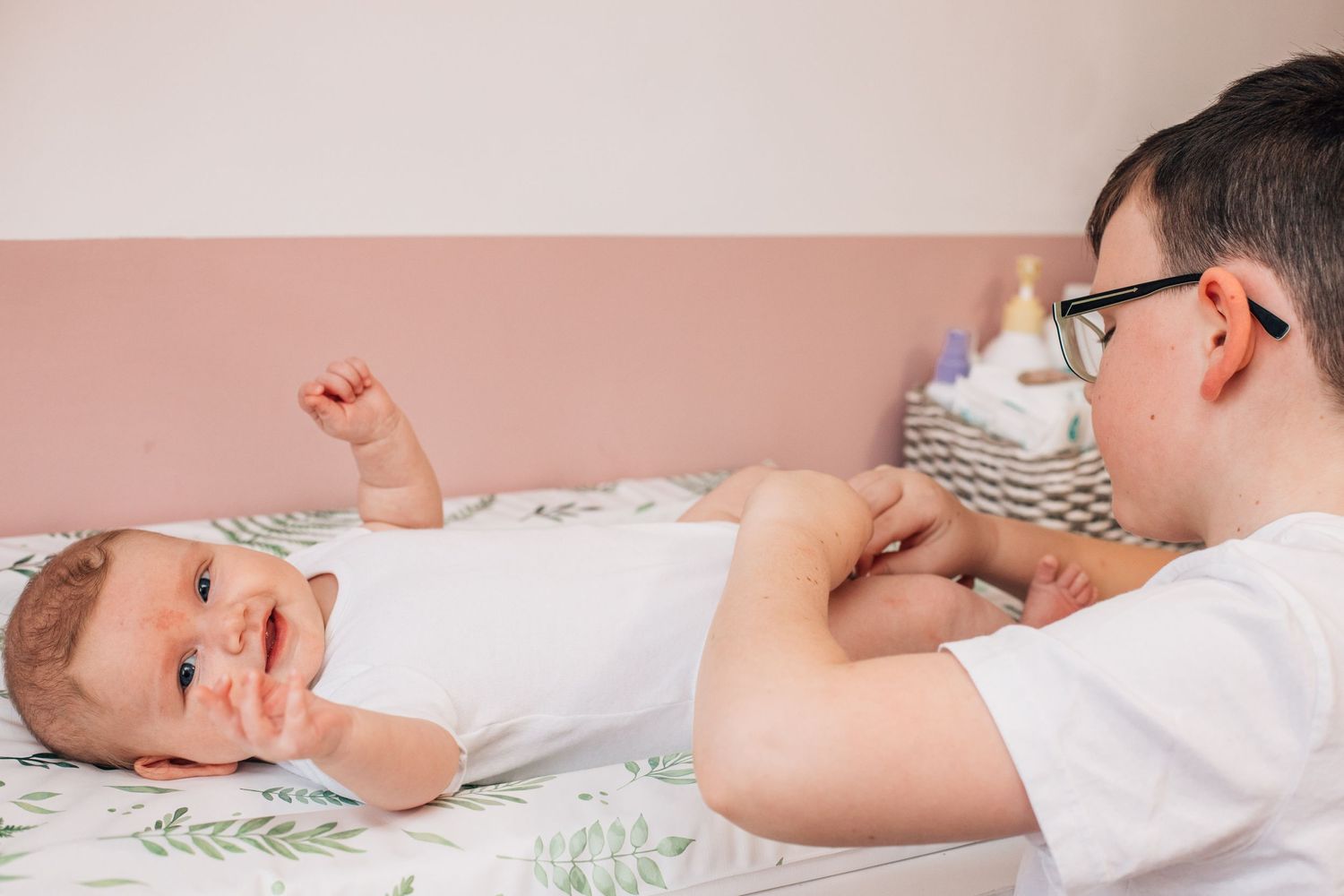 brother changing baby's nappy