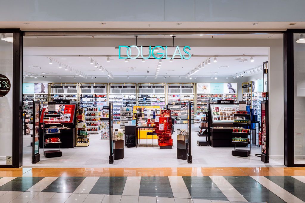 Spacious duty-free retail space with modern displays and striped floor pattern.