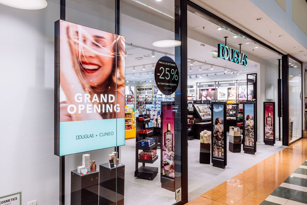 Bright retail corridor with illuminated storefronts and polished floors in a contemporary shopping center.