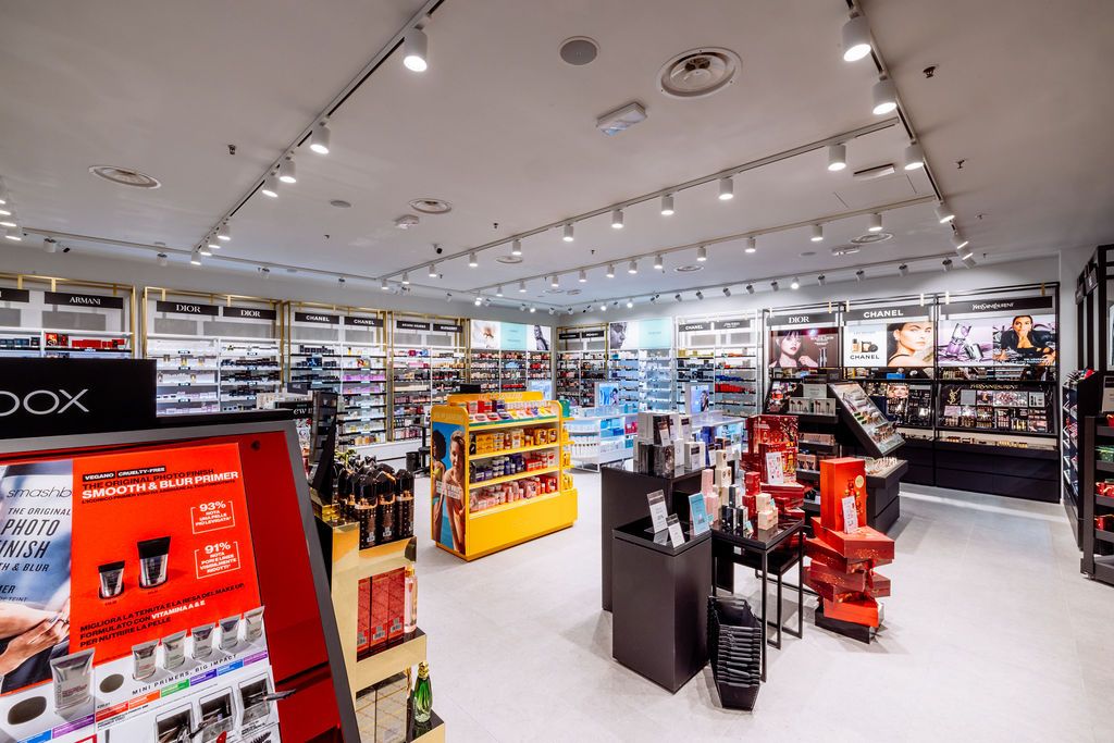 Modern retail store interior with track lighting and shelves displaying beauty and cosmetic products.