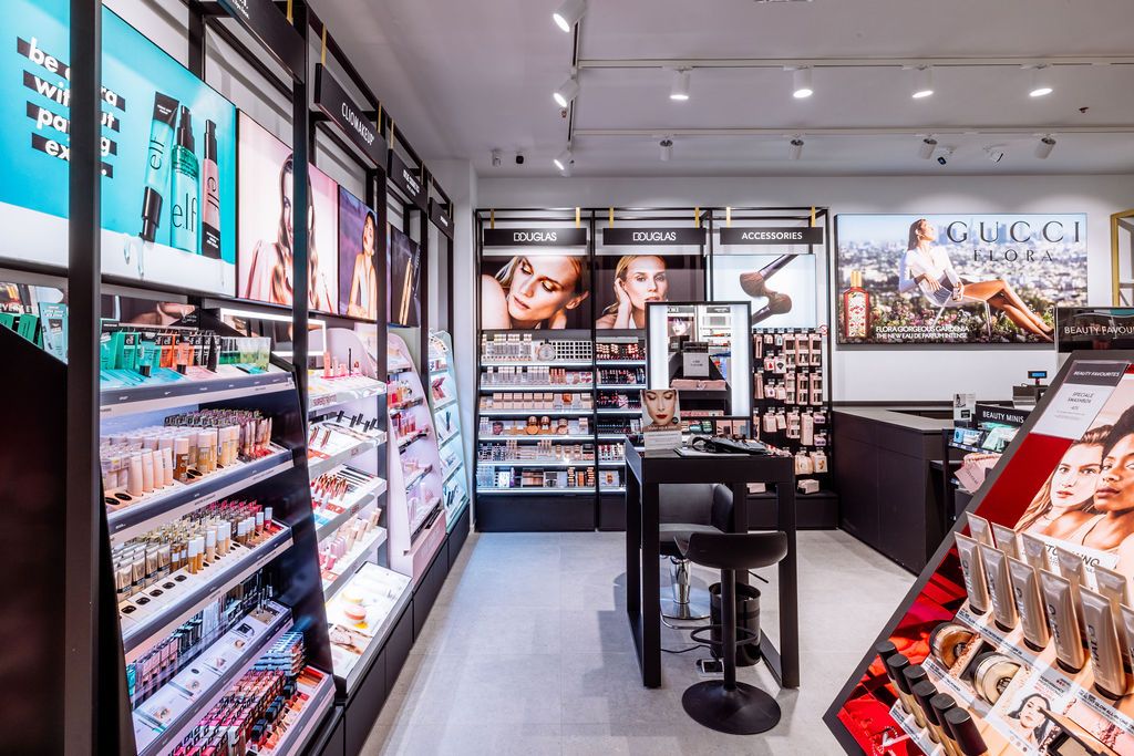 Panoramic view of a modern convenience store interior with bright fluorescent lighting and well-stocked shelves.