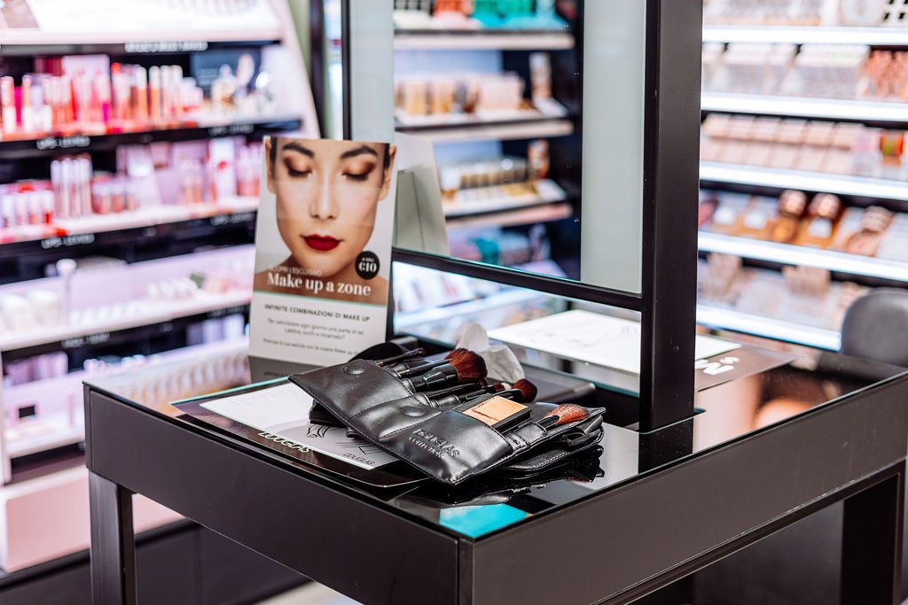 Professional makeup brushes and cosmetic products displayed on a counter in a beauty store.