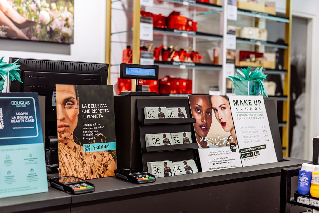Retail display shelves showing beauty products and cosmetics with illuminated signage and marketing materials.