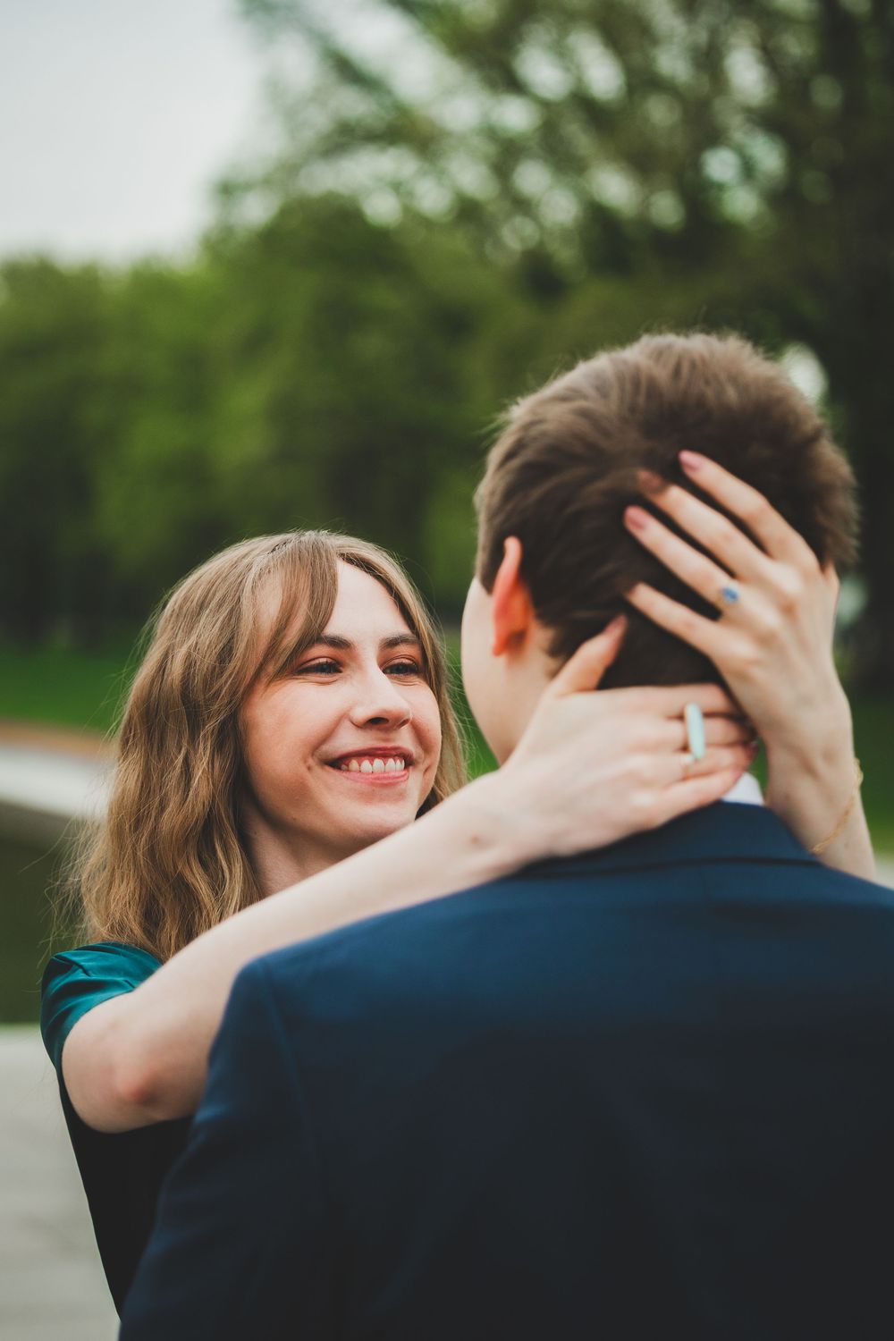 A joyful couple embraces outdoors while the woman playfully extends her arms in a series of candid moments.
