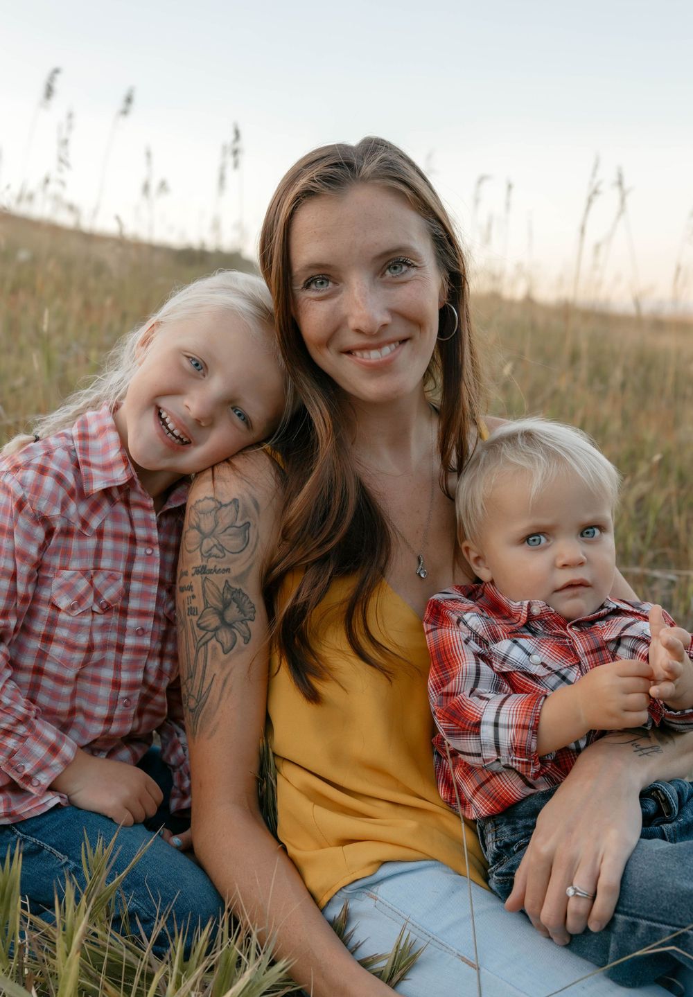 Family portrait in field with coordinating outfits and natural golden light.