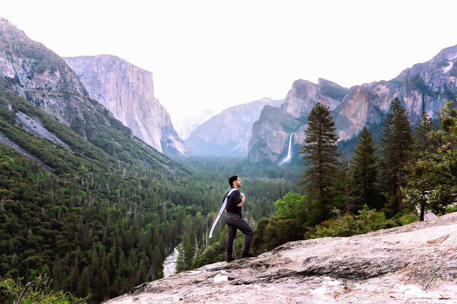 Yosmite,ca emotive story telling Photographer captures grad in strong and powerful pose with El Capitan, and Yosemite Falls in the distance.