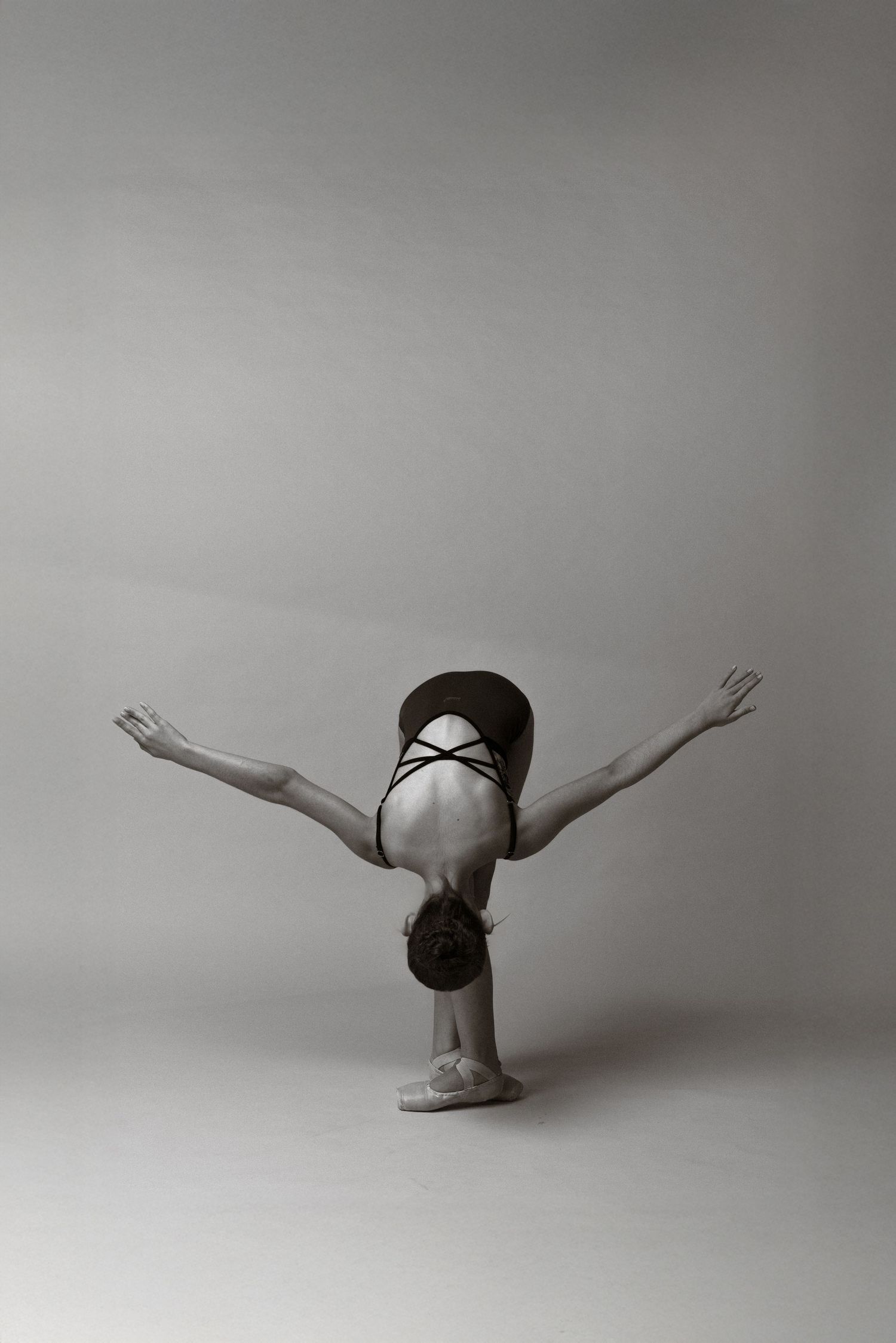 A black and white photo sequence shows a dancer performing a graceful rolling movement across the floor.