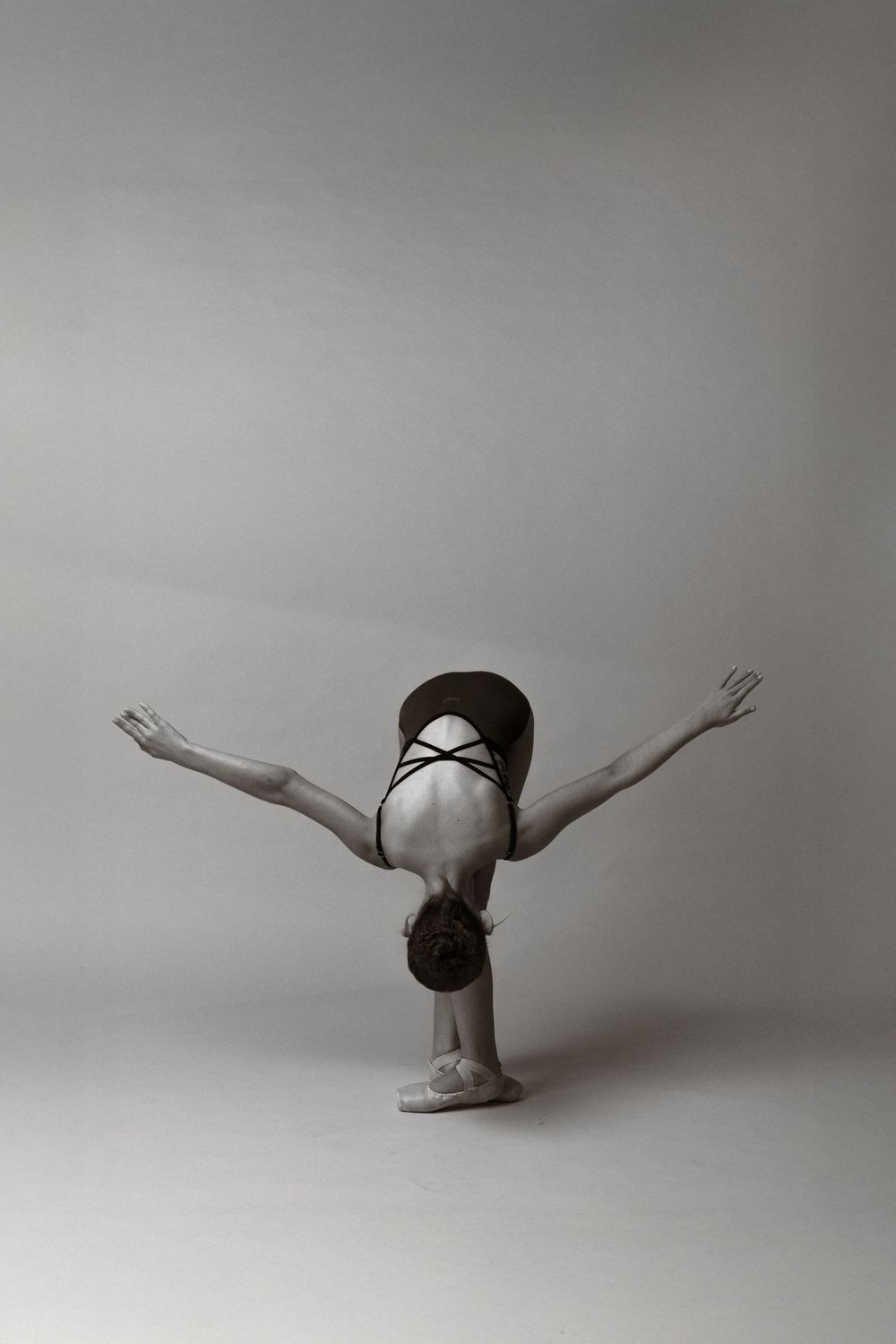 A black and white photo sequence shows a dancer performing a graceful rolling movement across the floor.