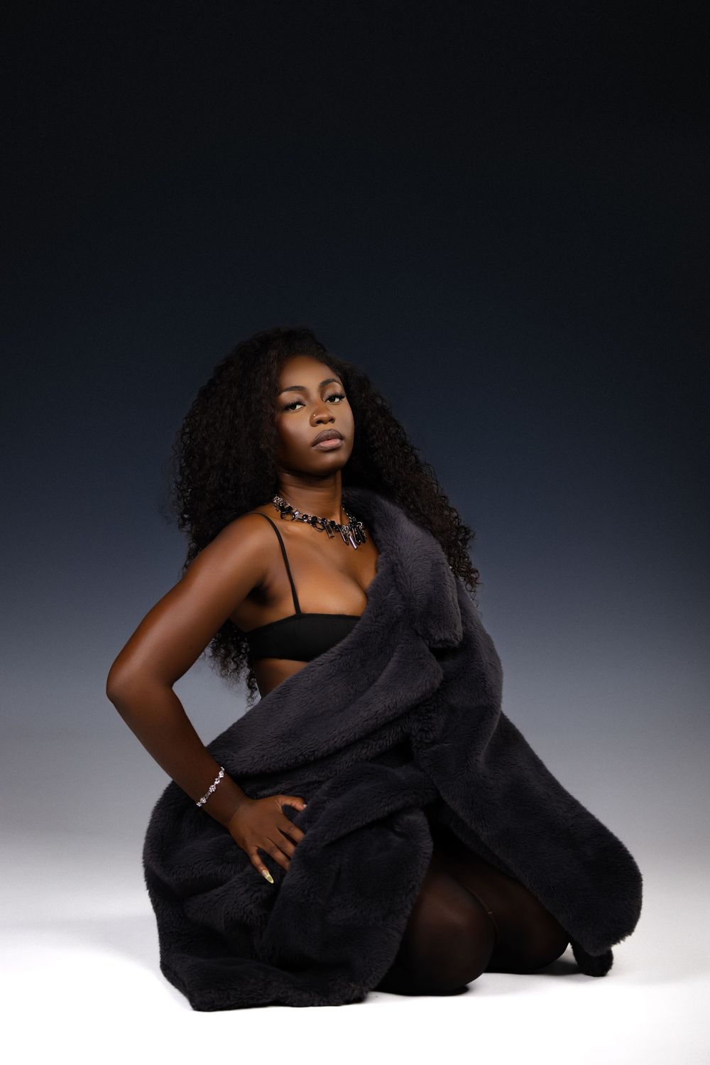 Artistic portrait series showing poses in black fabric against a dark background with dramatic lighting.