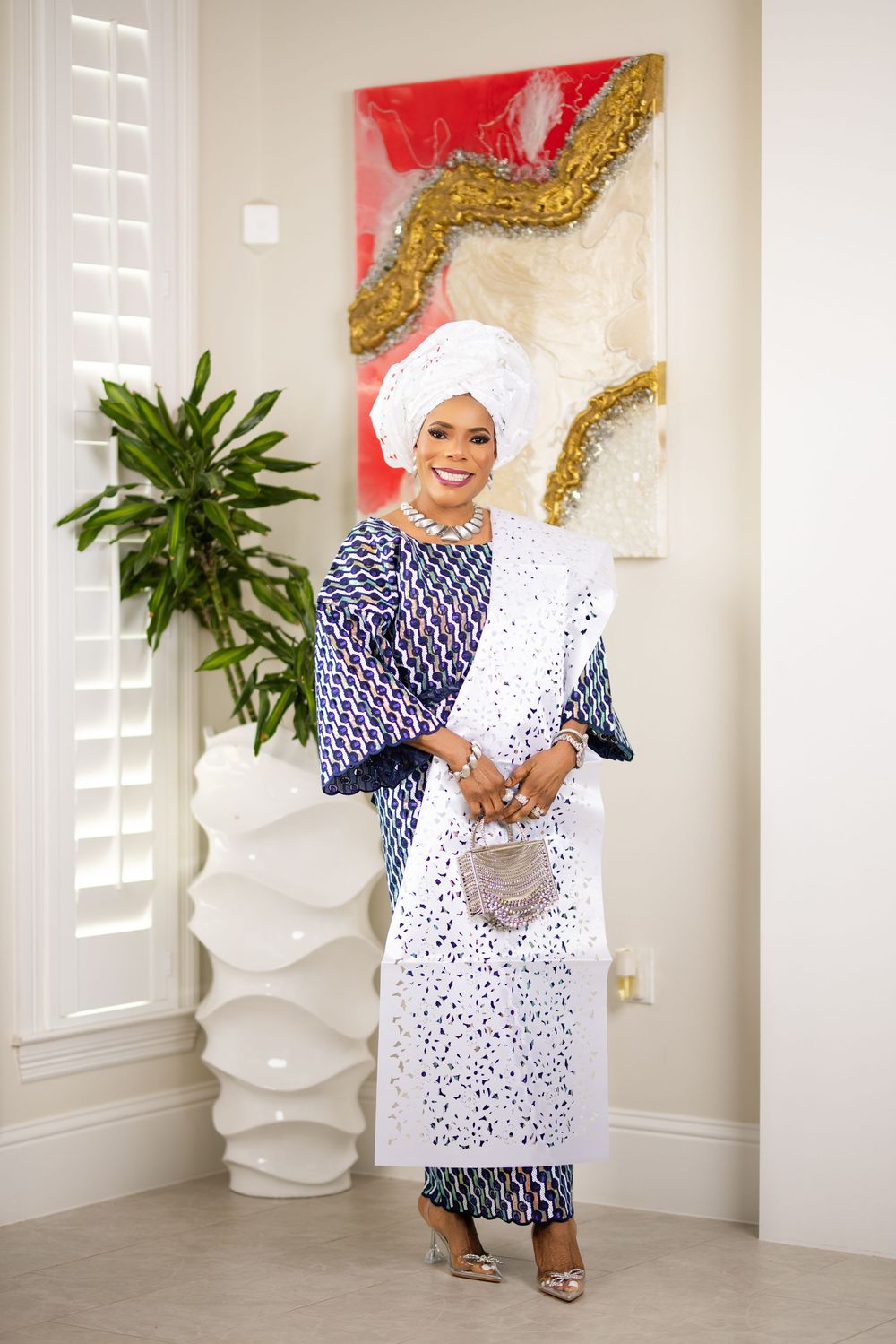 Traditional African-inspired fashion photoshoot featuring blue and white patterned dress with head wrap.