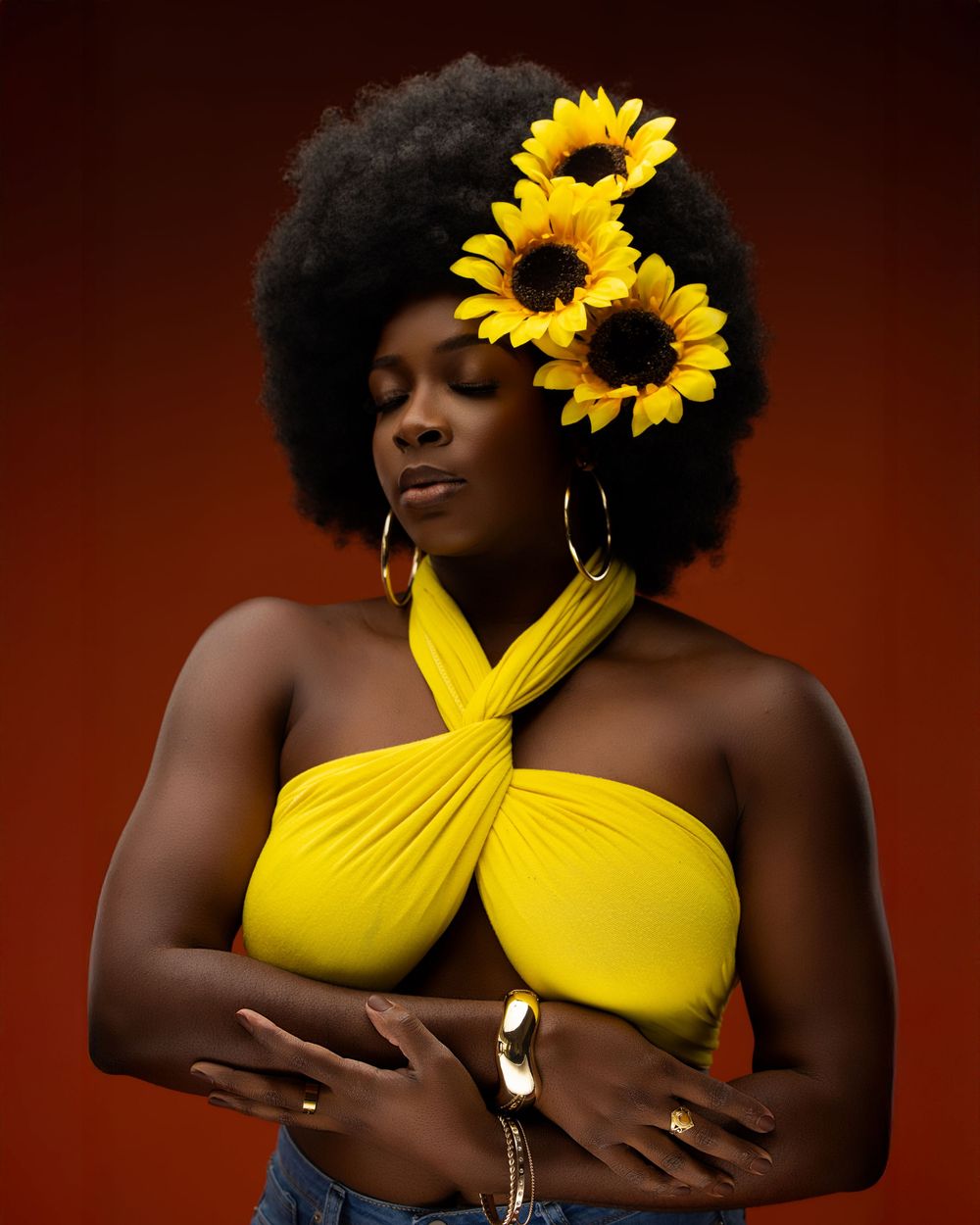 Artistic portrait series with yellow sunflower accents and one-shoulder top against dark background.