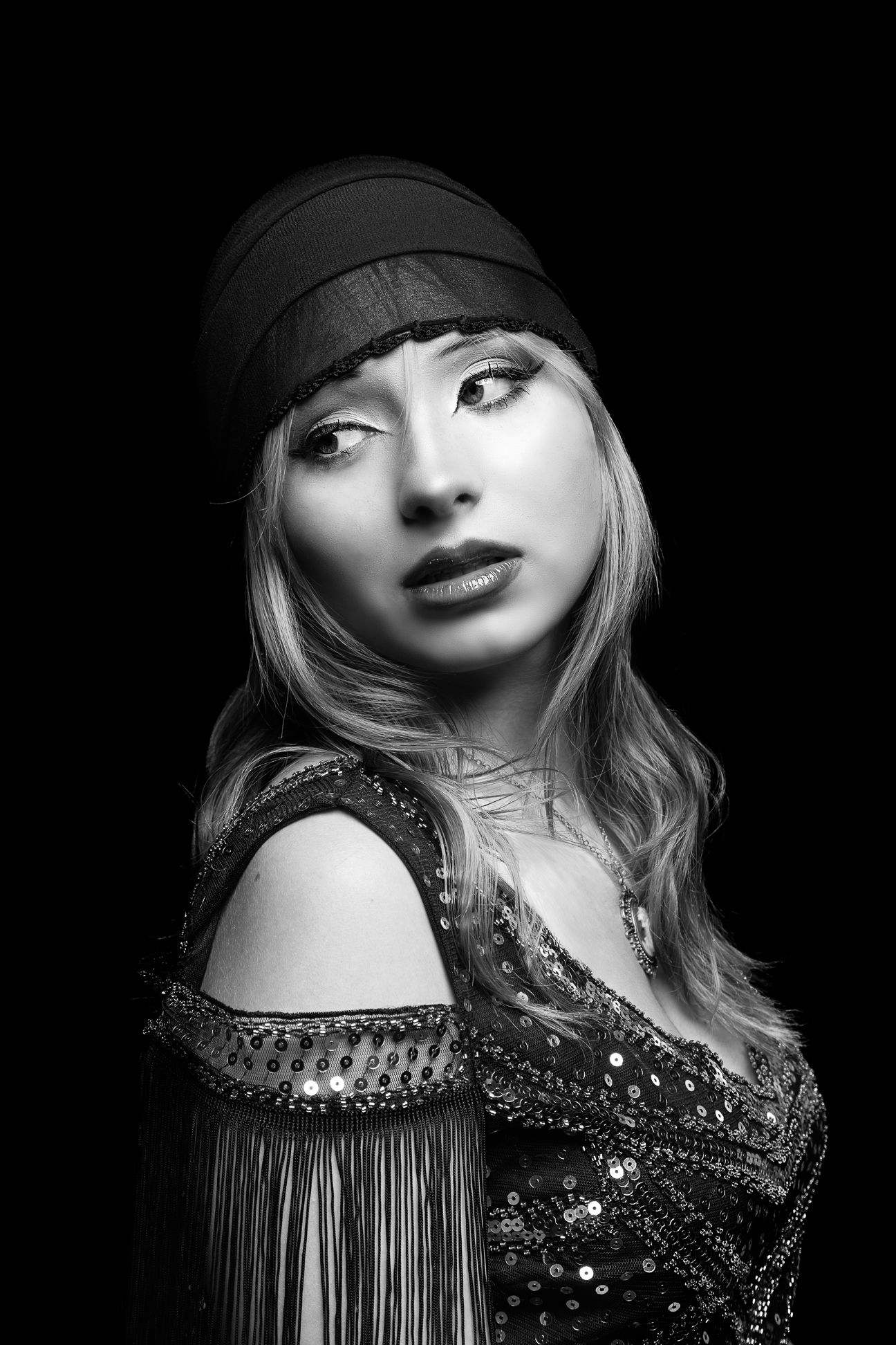 Black and white photo of a girl with a headscarf on, looking left