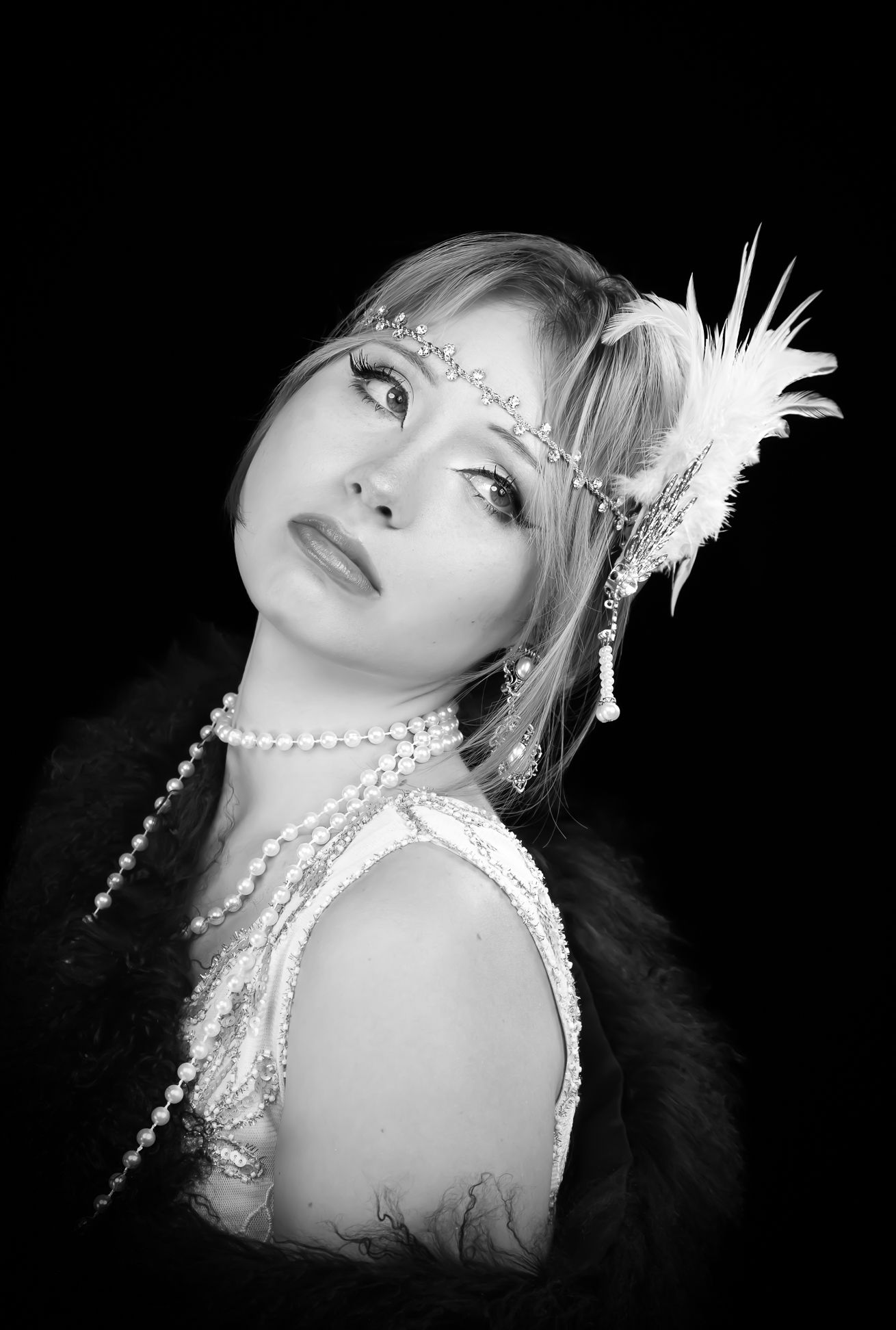 Black and white photo of a girl in a flapper costume, looking right