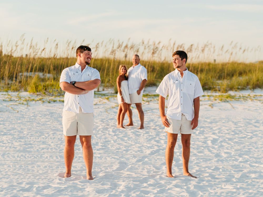 A romantic proposal sequence on a white sandy beach with figures in white clothing at sunset.
