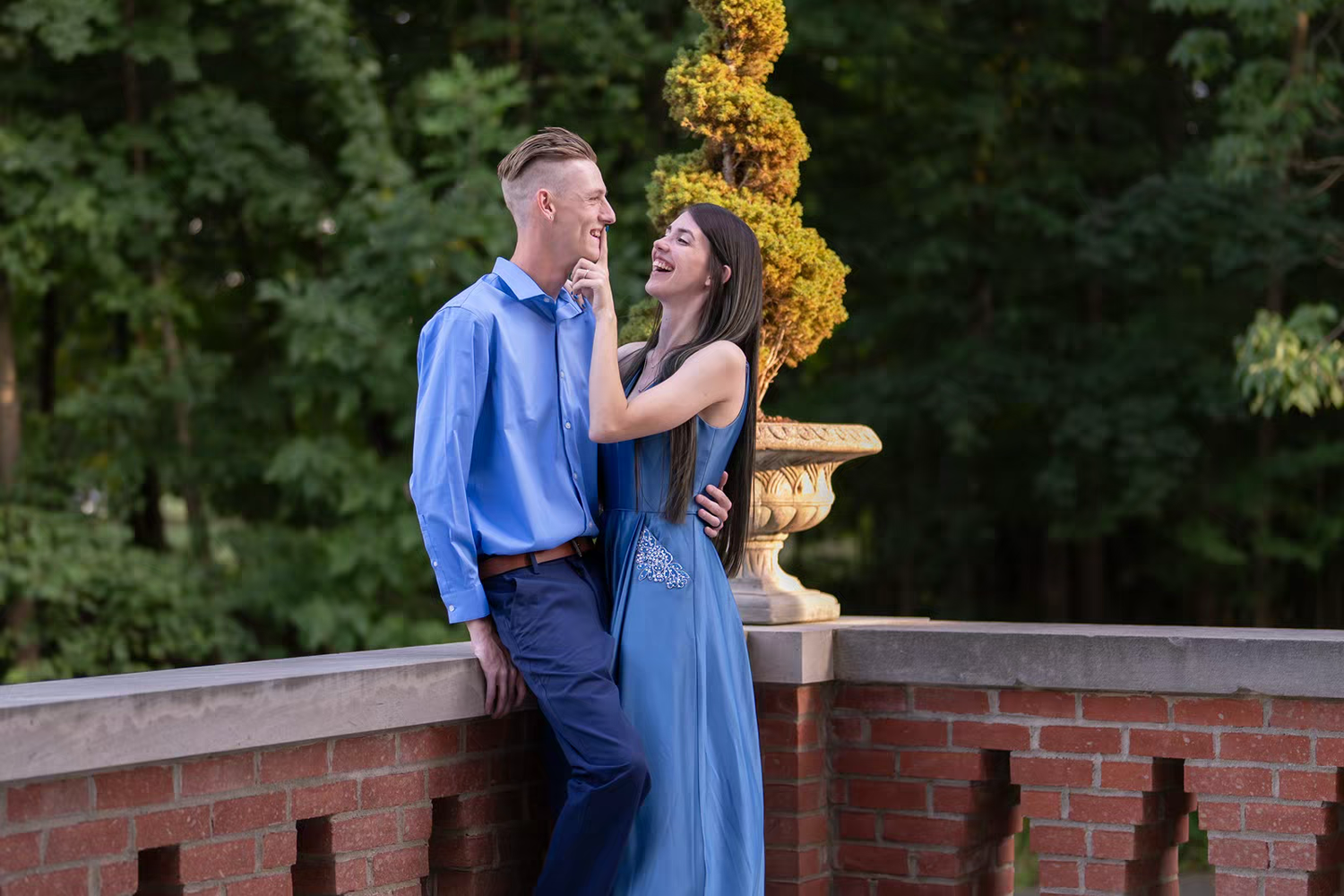 A romantic sunset photoshoot features a couple in coordinating blue outfits.