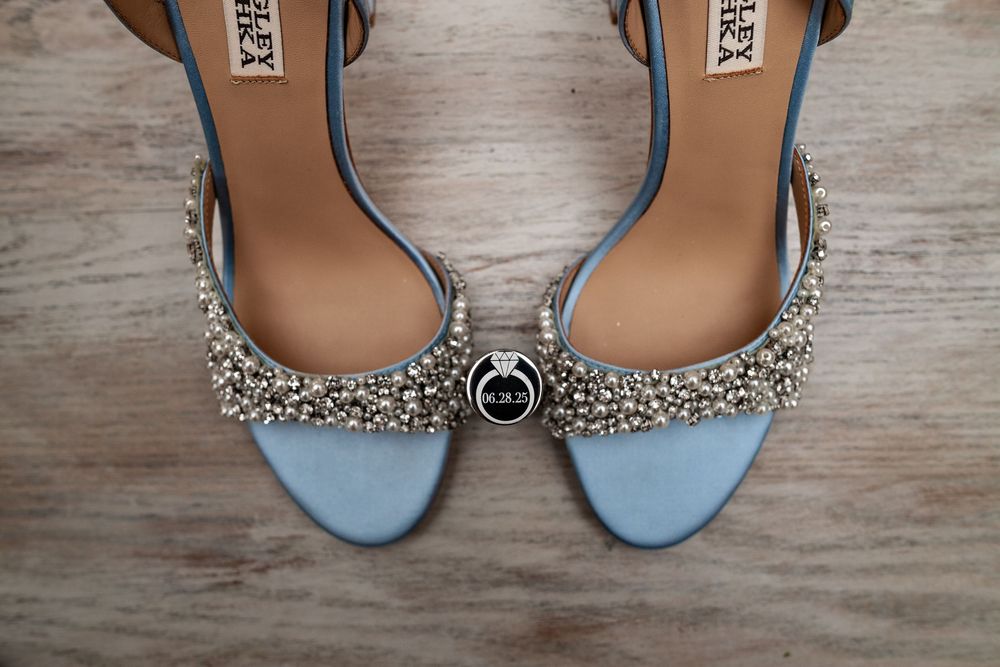 Collection of elegant women's dress shoes and sandals with sparkly embellishments displayed on a wooden surface.