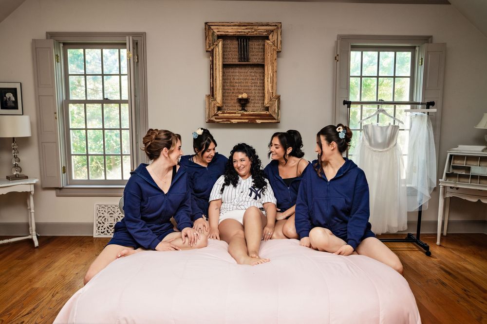 Group relaxing together on a pink couch in a bright sunlit room with white walls and wooden floors.