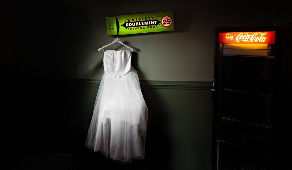 White dress displayed on a dark mannequin against a black background.