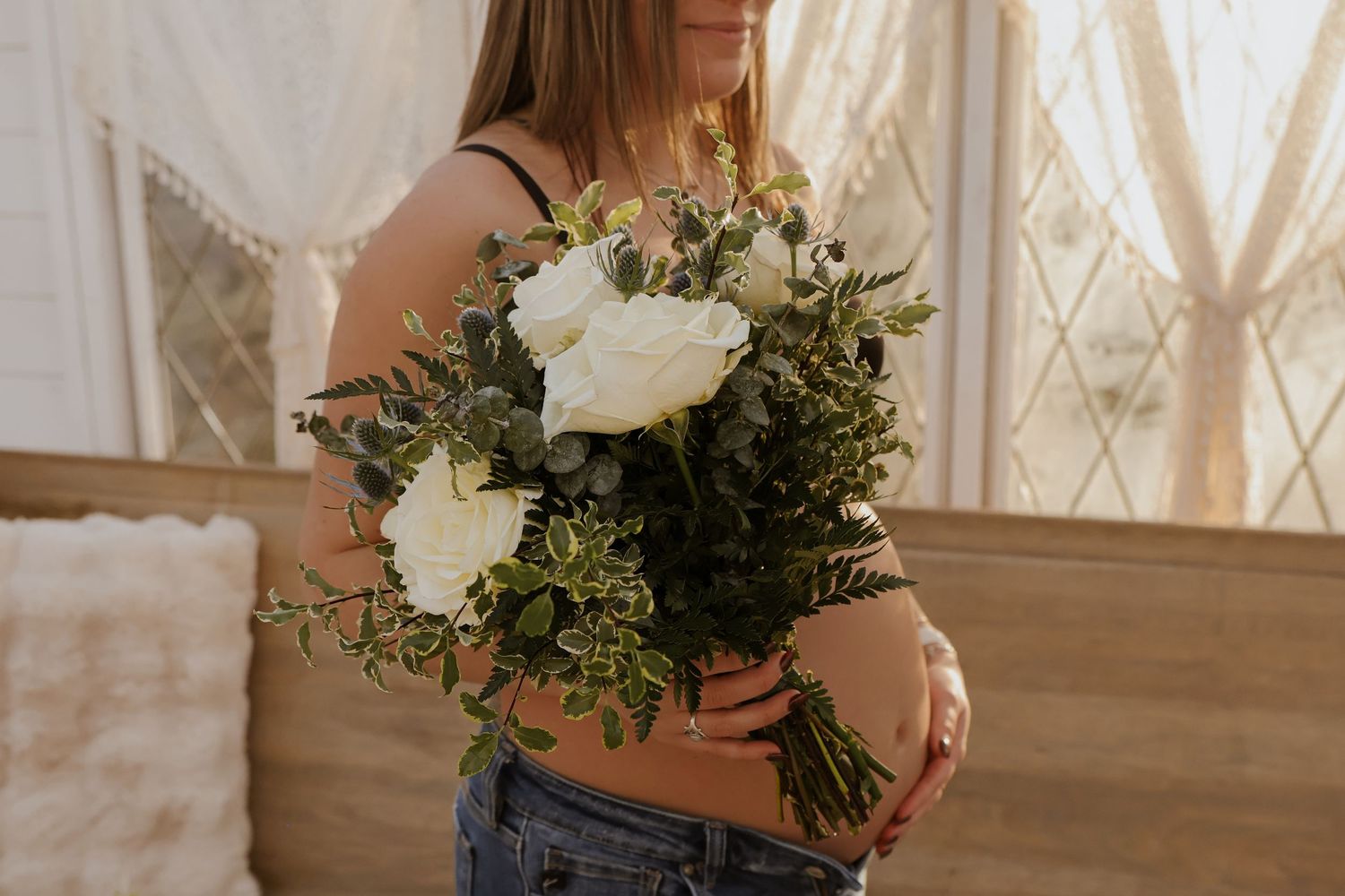 Elegant white floral arrangements and greenery displayed in a bright sunlit room.