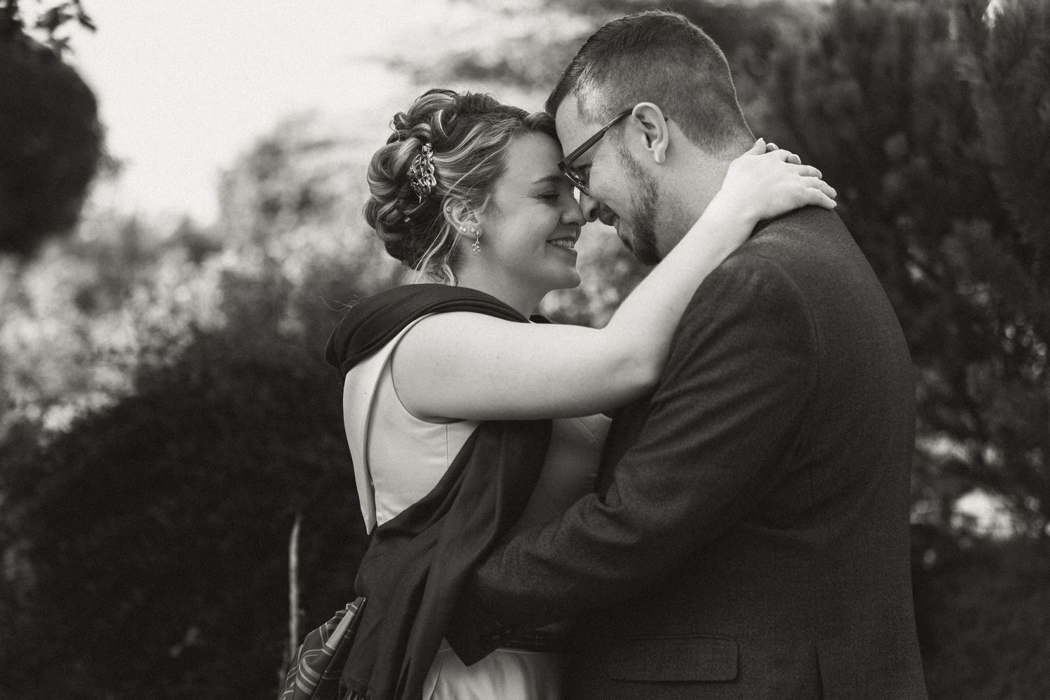 A romantic black and white photo series showing a couple embracing and kissing in an outdoor setting.