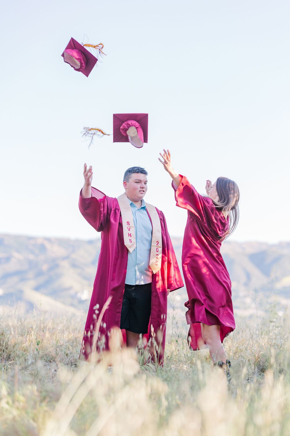 Simi High School twins posing in the hills of Simi Valley for outdoor graduation portraits, celebrating lacrosse and college milestones.
